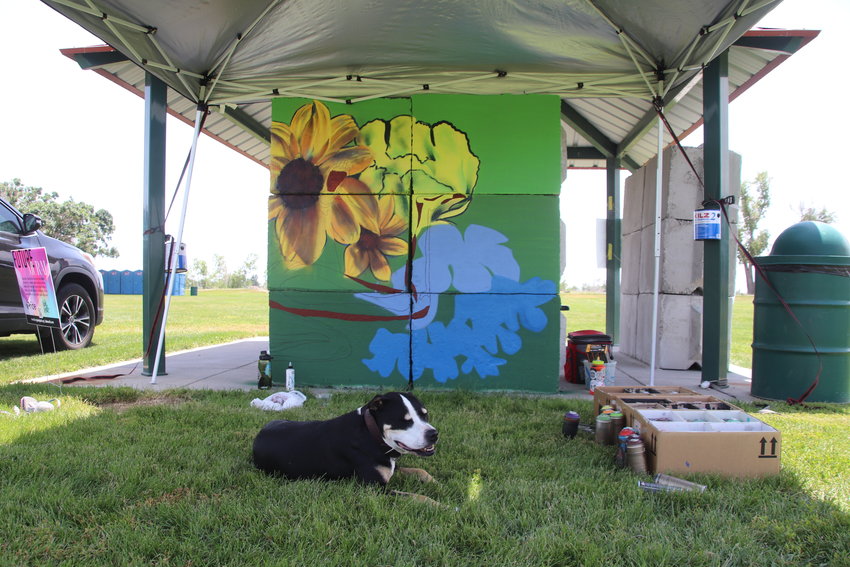A dog relaxes in front of Babe Walls member Ciara Bourne’s mural.